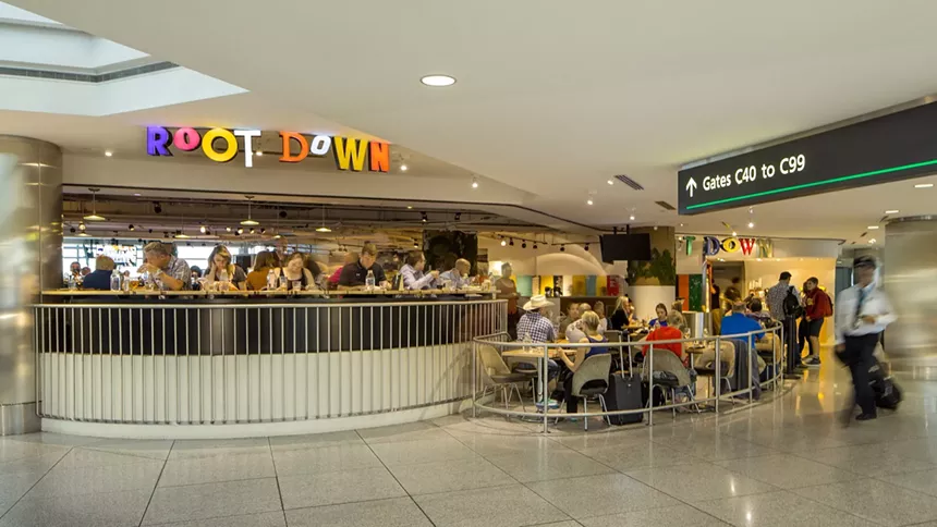 an airport gate sign hanging near the front of a busy restaurant