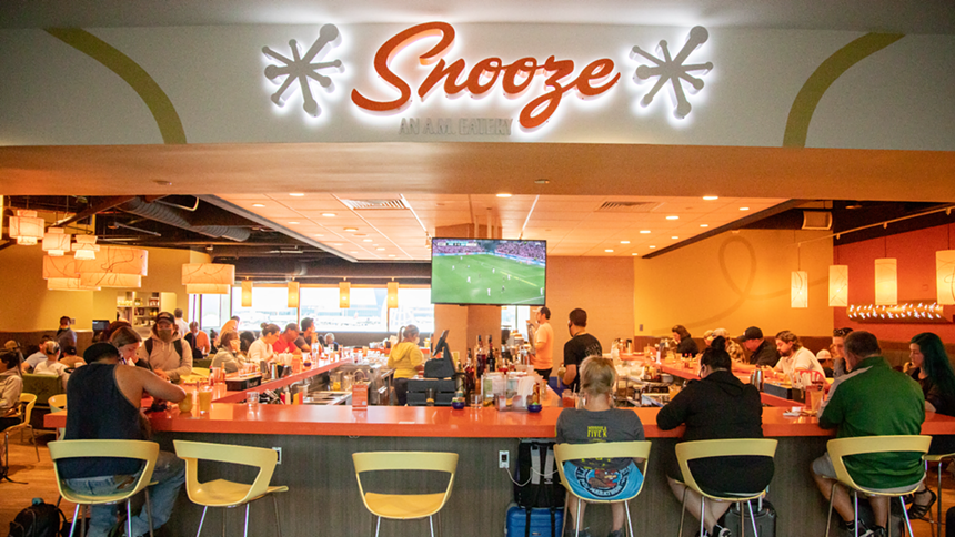 the front of a restaurant with an orange bar and yellow chairs