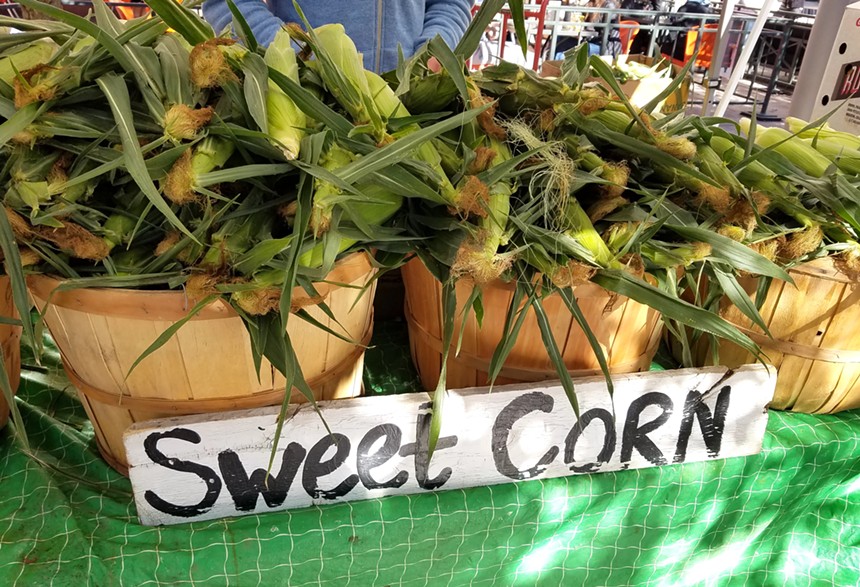 baskets of sweet corn at farmers market