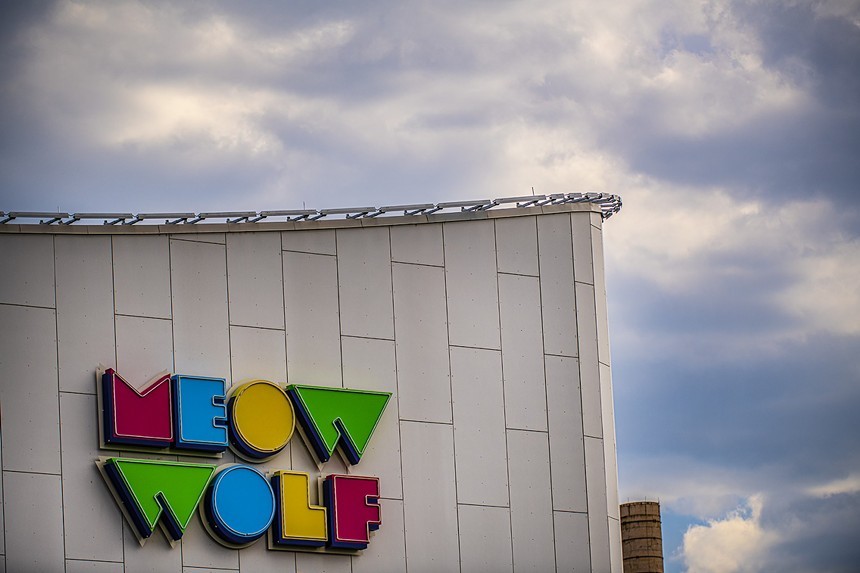 concrete building with the words "meow wolf" on it