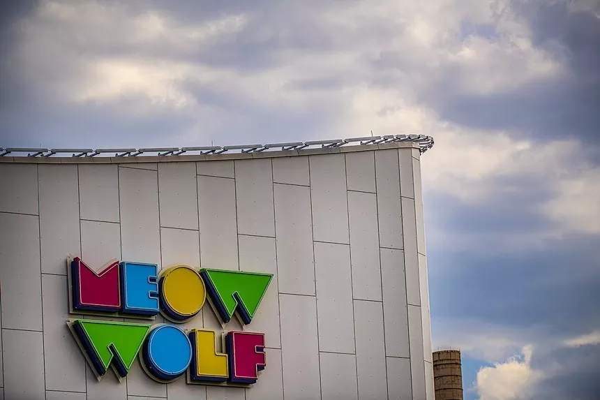 concrete building with the words "meow wolf" on it