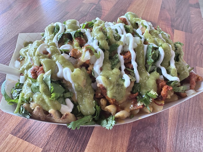 waffle fries topped with meat, cheese, cilantro, onions, guacamole and sour cream