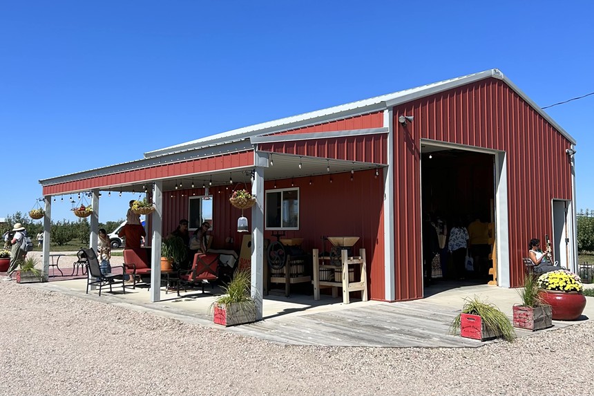 A barn-like structure with red siding and a covered patio, which serves as Adam's Country Store