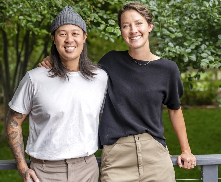 a man with long hair and a beanie next to a woman in a black t shirt