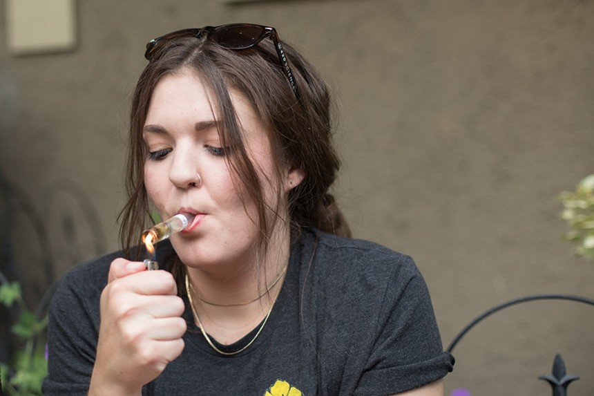 Woman lights chillum to smoke weed