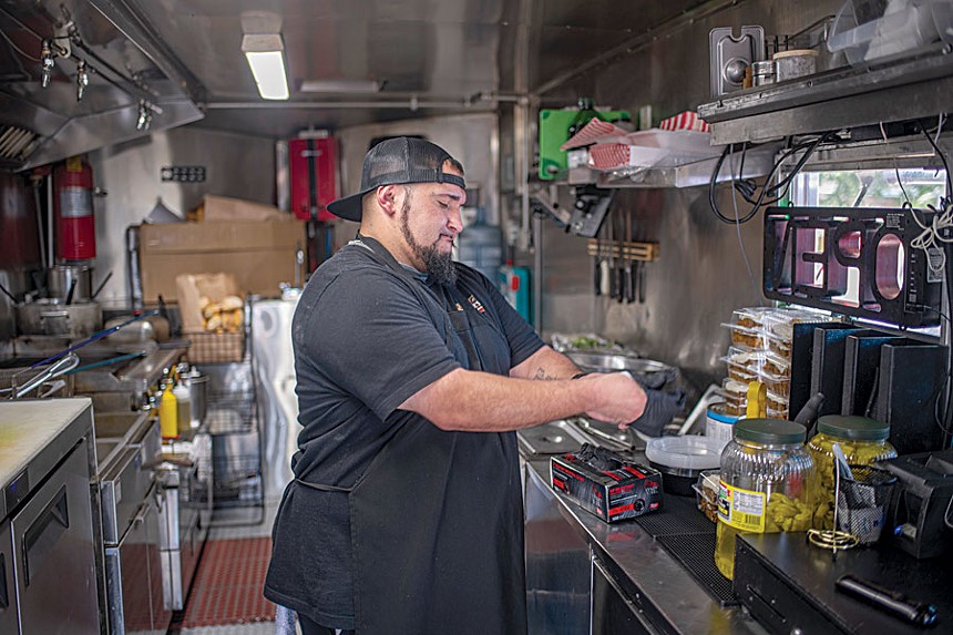 man at grill inside food truck