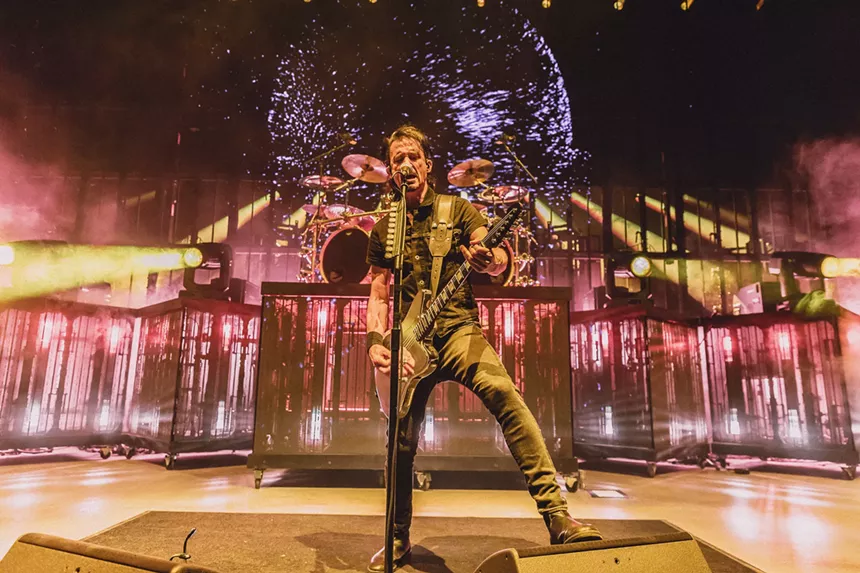 A lead guitarist at the front of the stage.