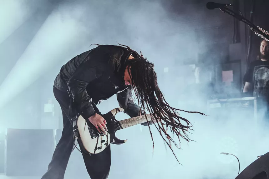 a man with deadlocks playing the guitar.
