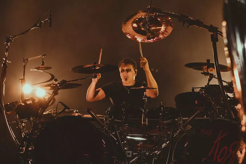 a man playing drums in front of a drum set