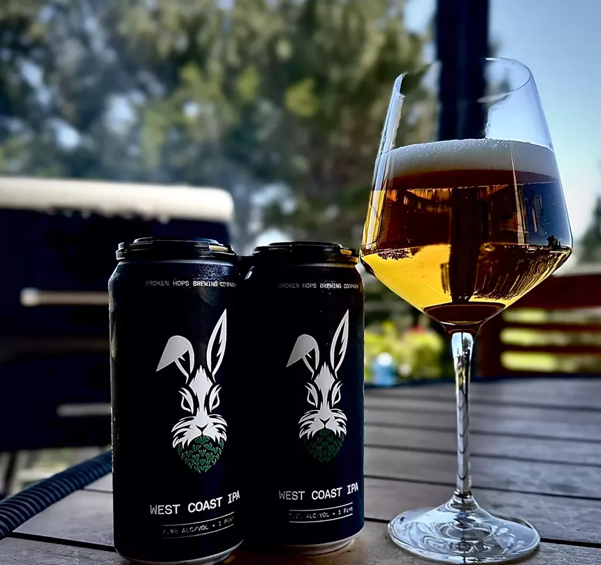 Two cans of beer with a rabbit and a glass of pale beer.