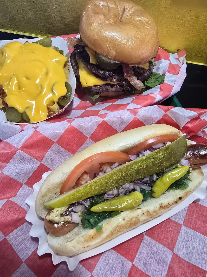 a chicago-style hot dog, a burger and Frito pie