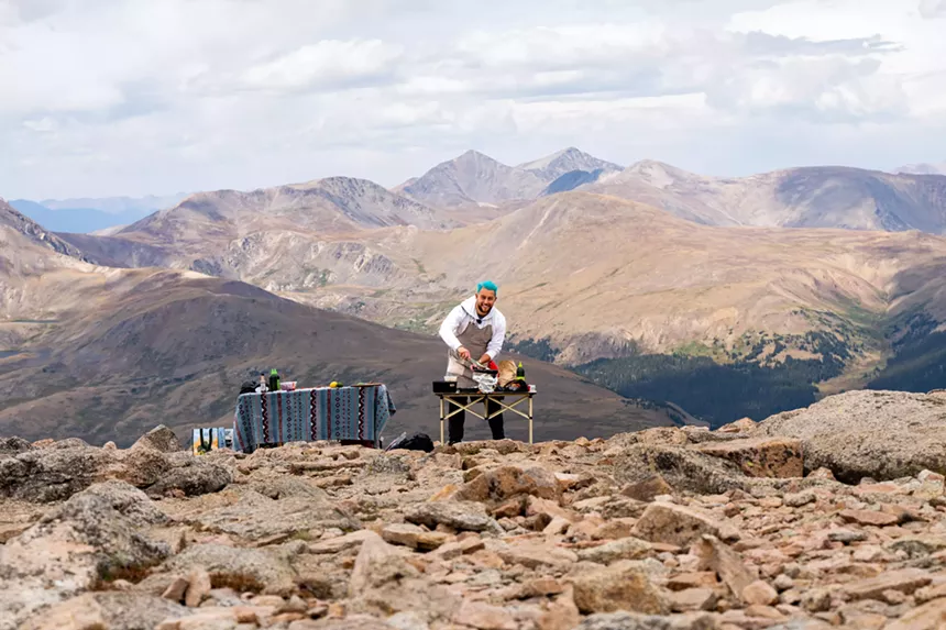 Connór Lock cooking from Mount Bierstadt while backdropped by mountain views