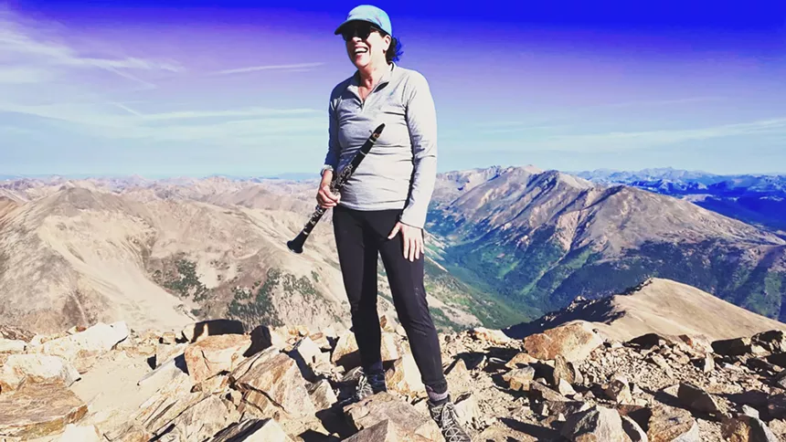 Stephanie Zelnick holding her clarinet on the Mount Elbert summit