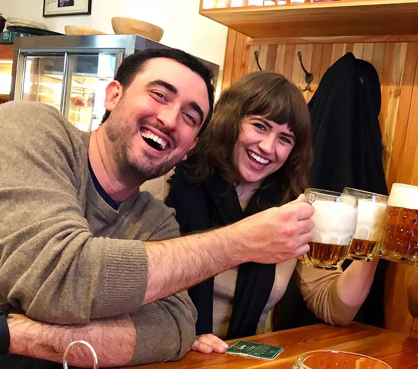 Two brewery owners holding foam-filled glasses of Czech lager.