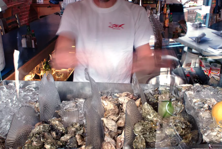 person working behind an oyster bar