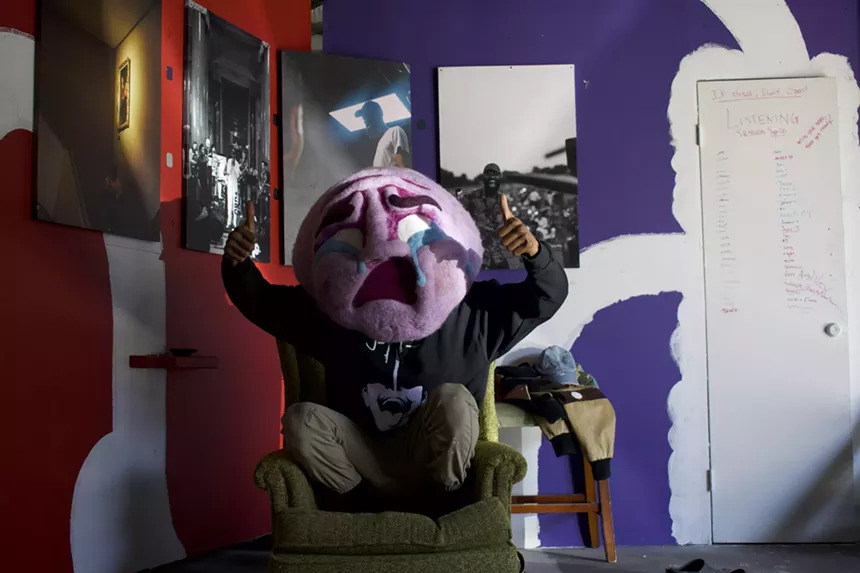person in chair with crying mask.