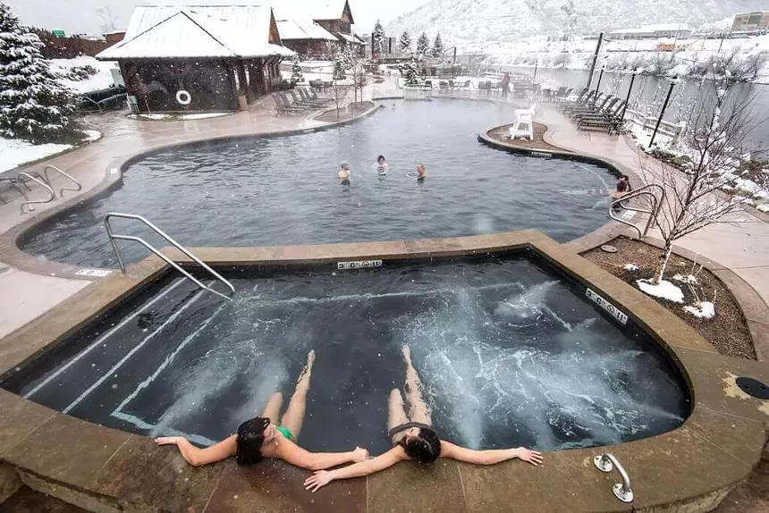 Two women soaking in a pool at Iron Mountain Hot Springs during the winter