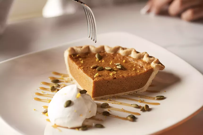 A fork hovering above a slice of pumpkin pie from Kona Grill