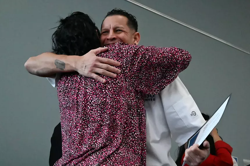 A man hugs.