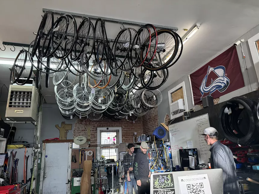 Bikes hang on a rack in bike shop