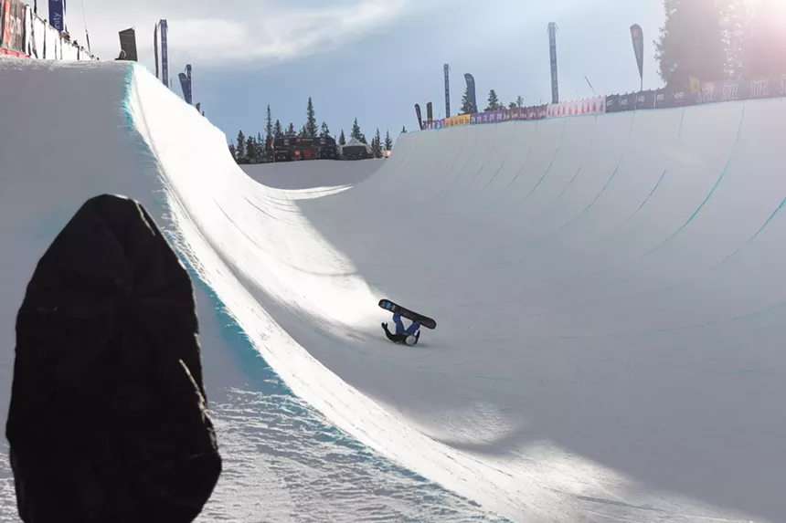 Snowboarder falls in halfpipe