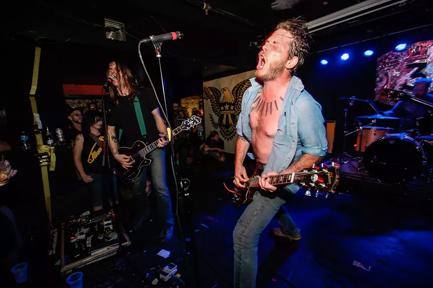 Gared O'Donnell playing guitar and screaming.