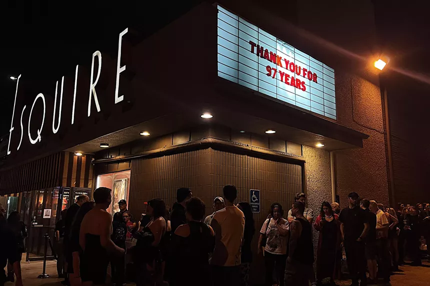 A line outside of the Esquire Theatre, with the marquee reading, "thank you for 97 years."
