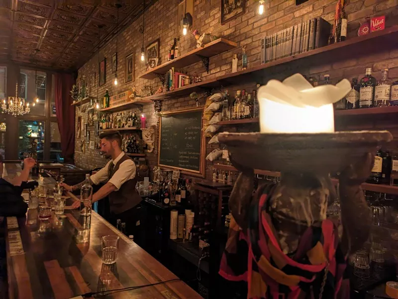 man standing behind a bar