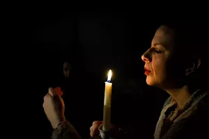 A woman blows out a candle.