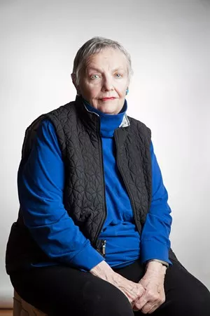 woman in black vest, blue shirt