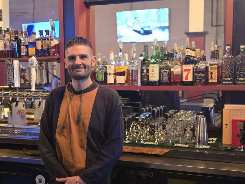 man posing in front of a bar