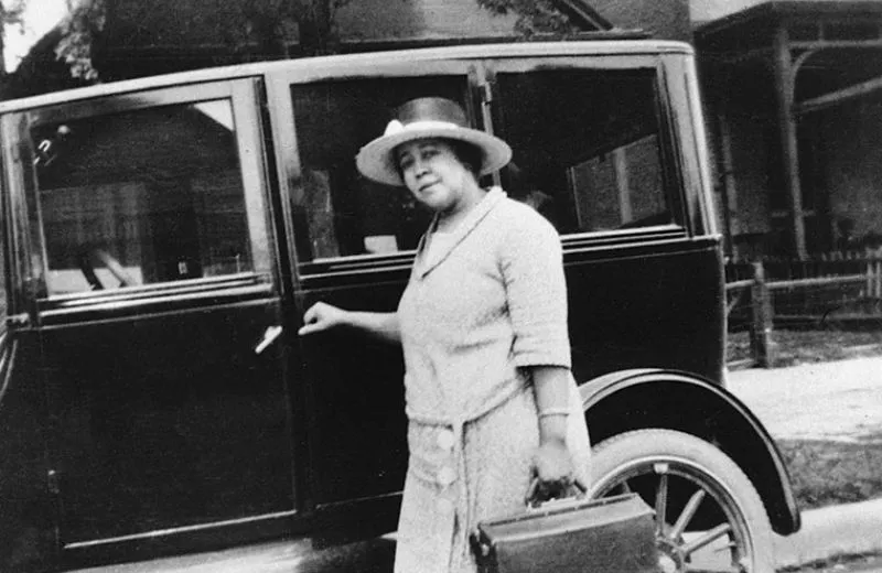 black woman doctor getting in old car