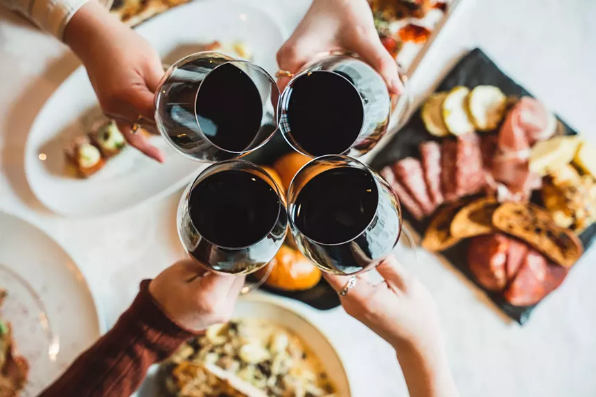 Four people toasting glasses of red wine at Jill's Restaurant & Bistro