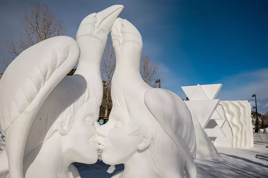 swans turn into people kissing in ice.