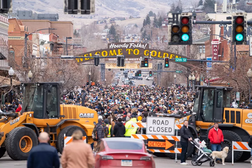 a traffic sign blocks the street in front of the crowded event