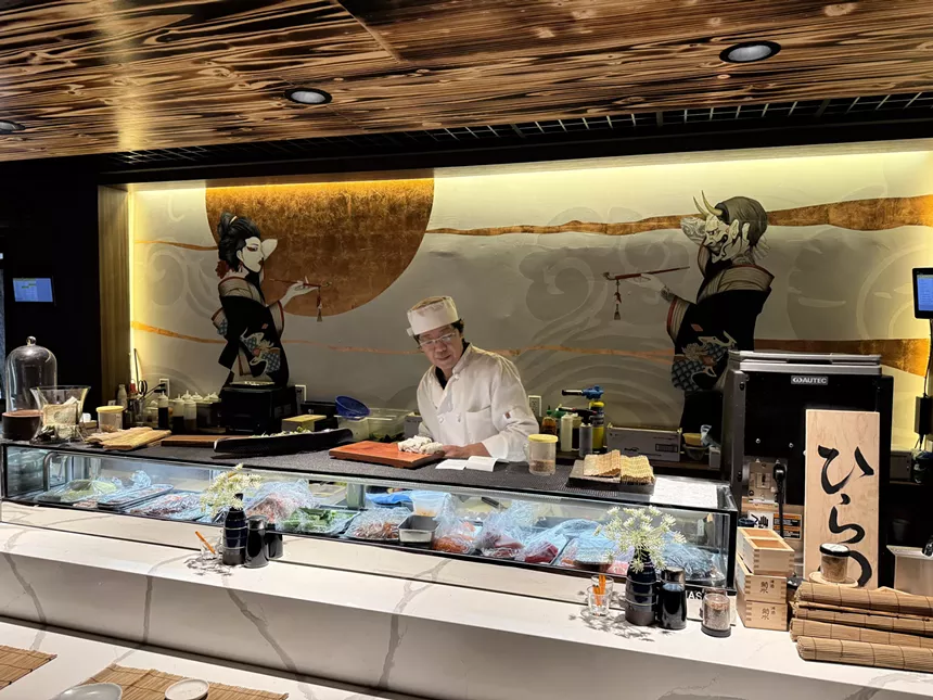chef behind a sushi counter