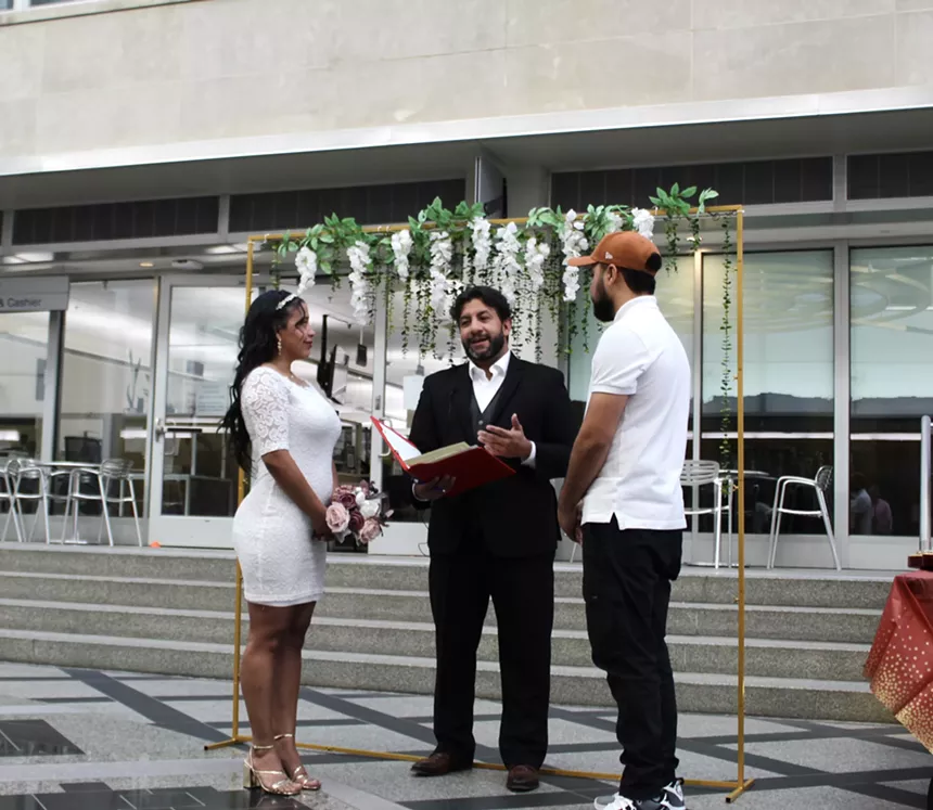 The Denver Clerk and Recorder marries a couple dressed in white