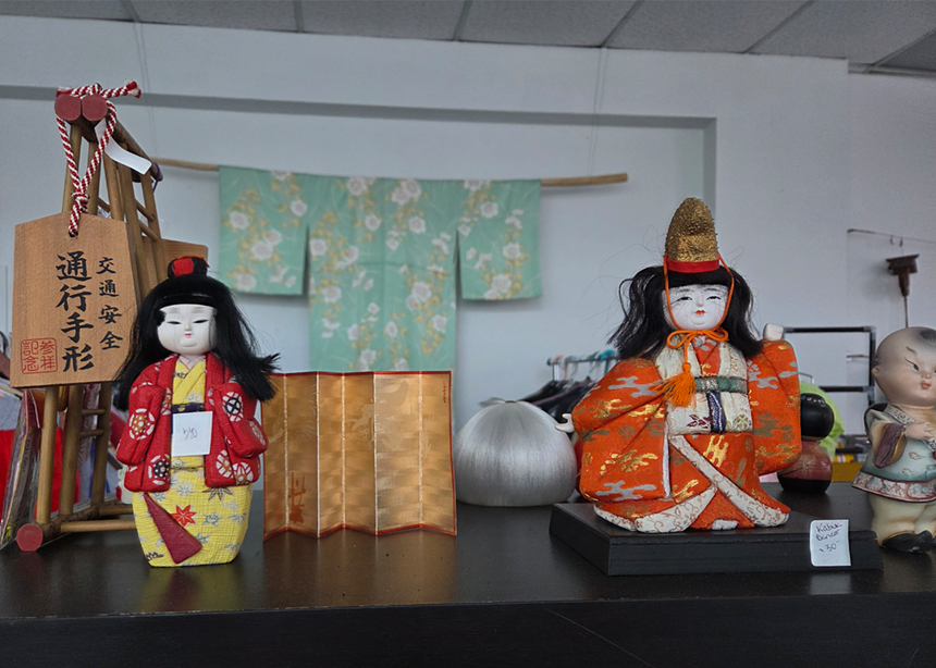 Two traditional Japenese dolls displayed on a shelf