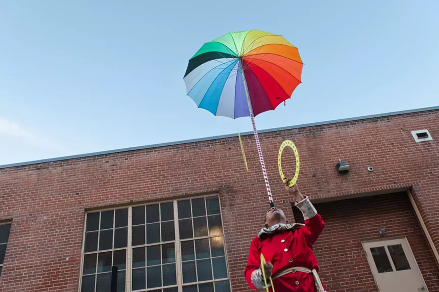 A person balances a colorful umbrella