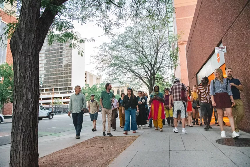 People walk down a city street