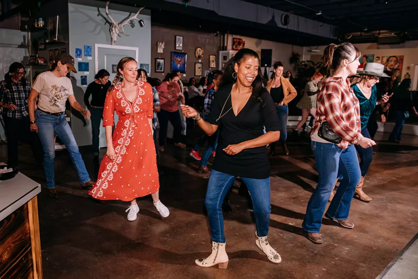 Women dance together.