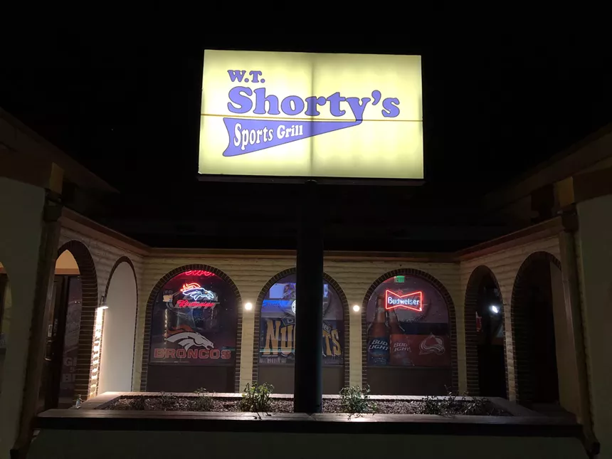 yellow sign in front of a dive bar