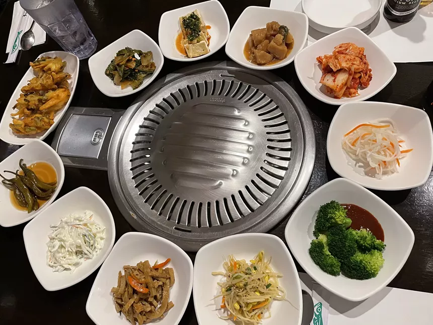 banchan surrounding a tabletop grill