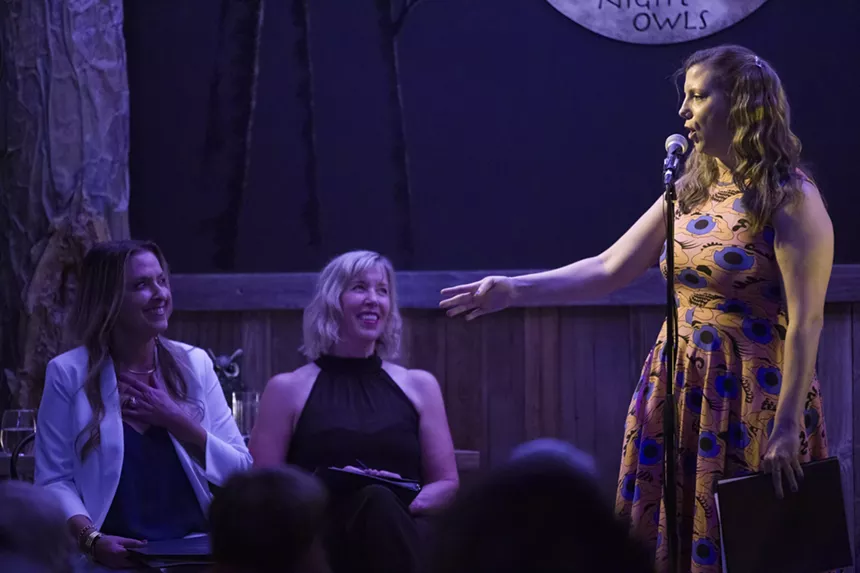 A woman performs while two women watch her.
