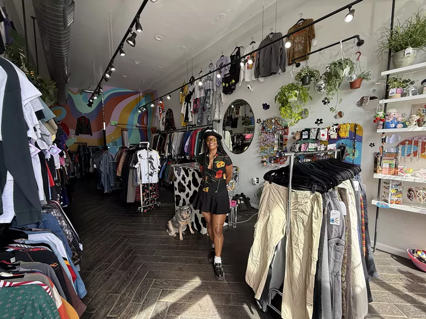 A woman and a dog stand in a vintage shop