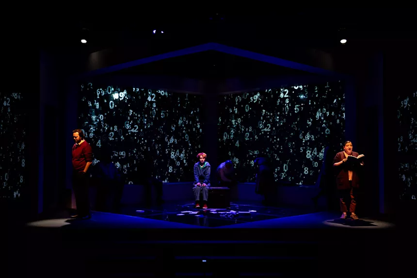 A boy is overwhelmed by the projections of numbers around him.