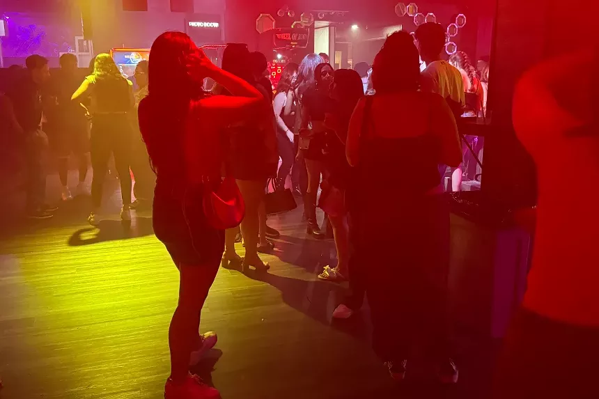 People stand on a dance floor.