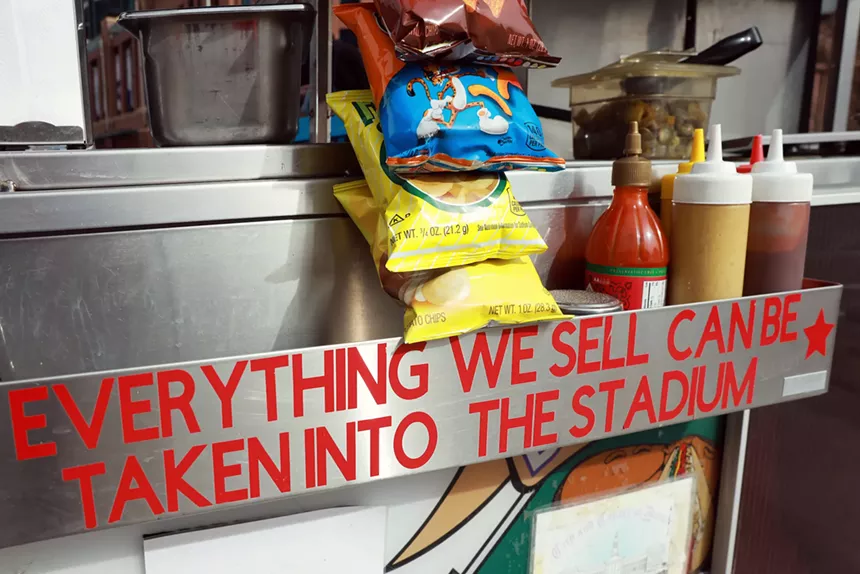 bags of chips hanging on a hot dog cart