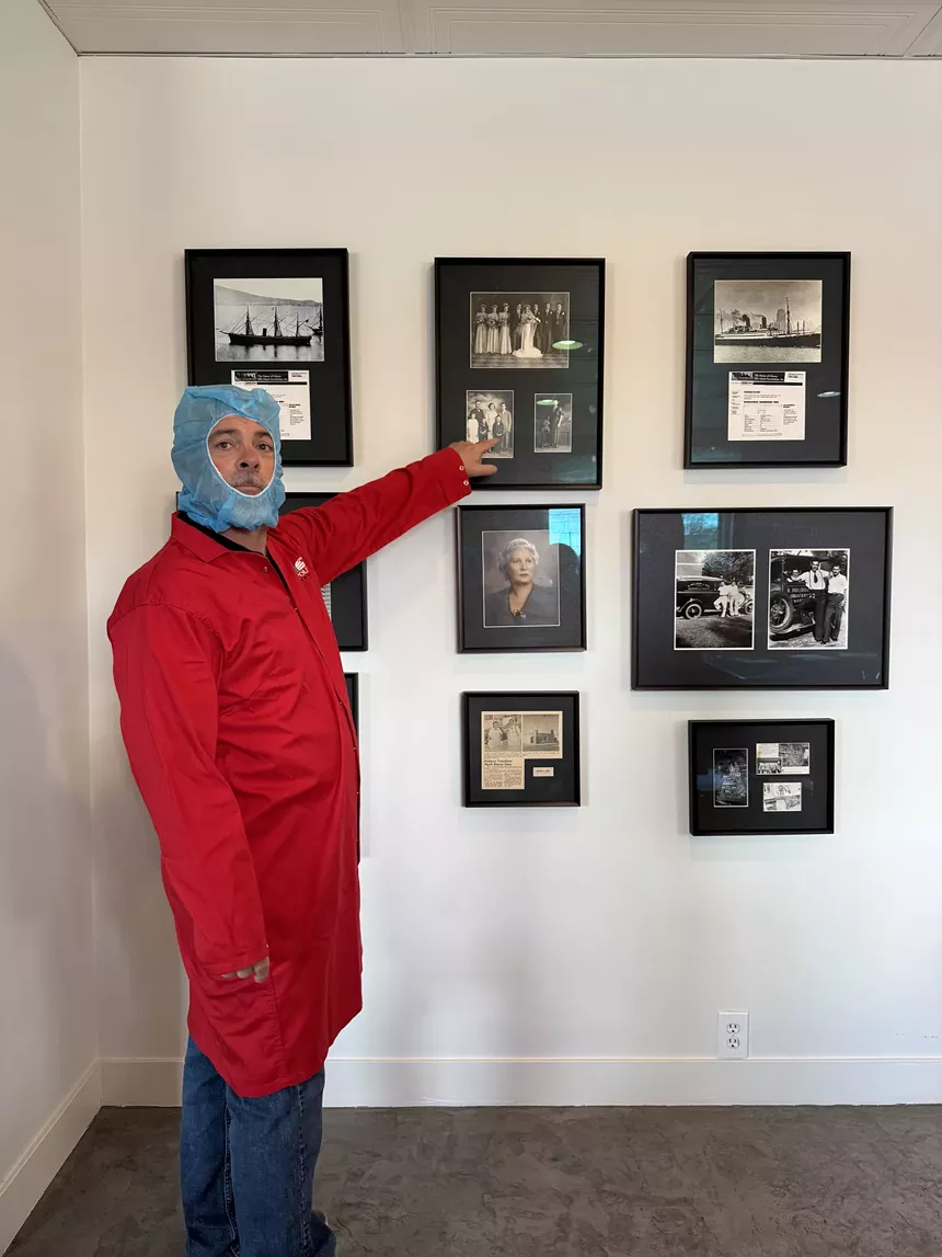 man pointing at photos on the walls