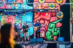 band performing in front of a trippy mural